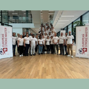 Group shot of Stroke Master Programme students in Bern. Inside the hospital, with MAS Programme flags